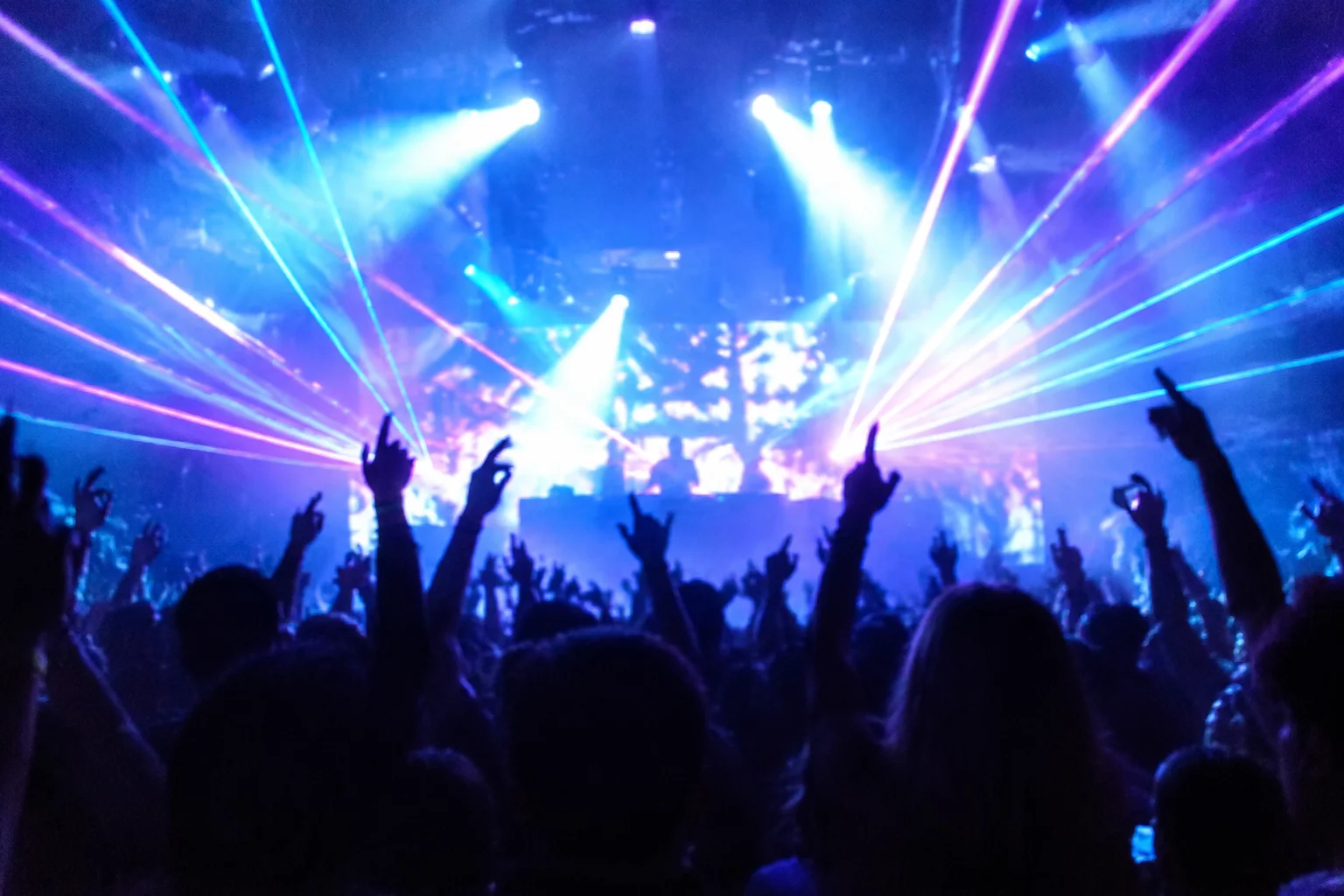 Club lighting illuminating hands on professional DJ media player